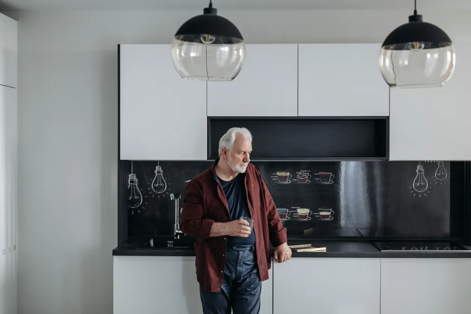 Senior man standing in his kitchen at home