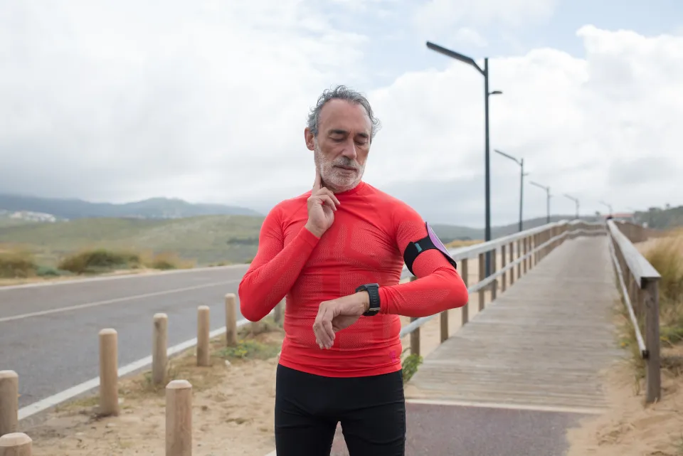Runner checking his watch on an isolated coastal trail