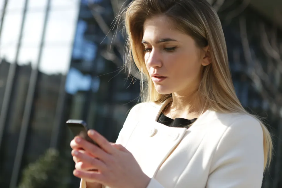 Woman checking her phone on a city street