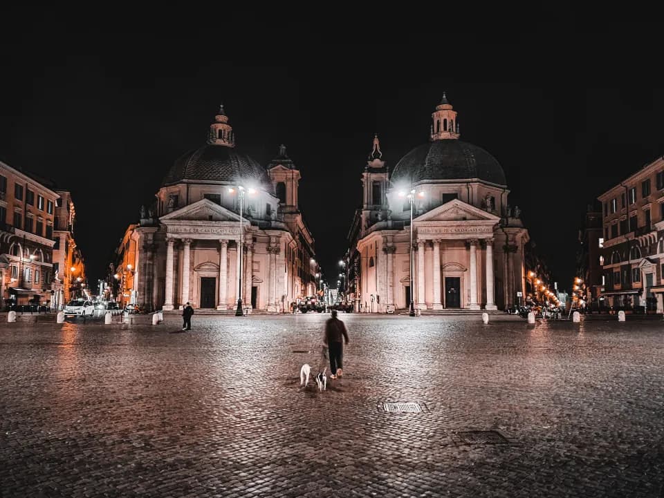 Person walking through an empty square at night